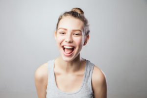 Psoriasisliiton esitteet-sivu, jonka kuvassa tyttö nauraa suu auki.