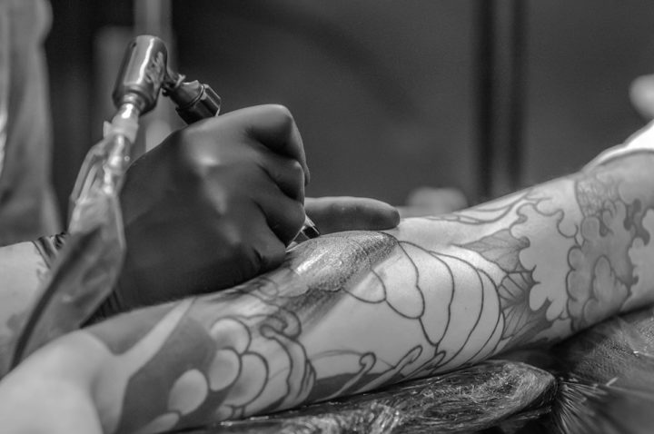 Mustavalkoinen kuva käsivarresta, jota tatuoidaan.