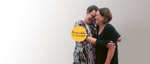 Kaksi naista halaa, kuvan päällä keltaisessa pallukassa teksti Psoriviikko 5.-11.4.21.