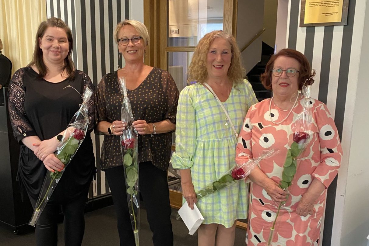 Lahden seudun psoriasisyhdistyksen hallituksen jäseniä Vuoden yhdistys -palkinnon jakotilaisuudessa ruusut kädessään.