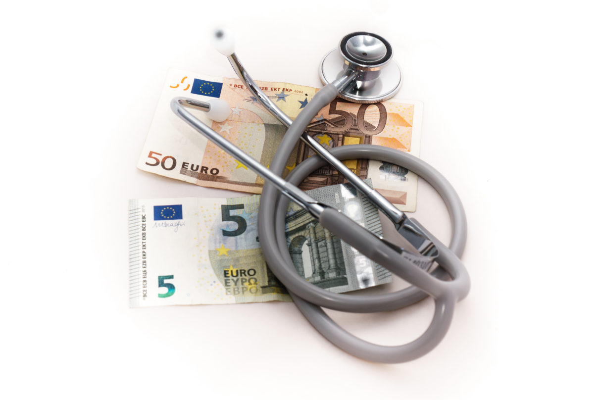 Stetoskooppi, jonka alla on 50 ja 5 euron setelit.