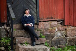 Maria Karras istuu portailla Porvoon vanhassa kaupungissa.