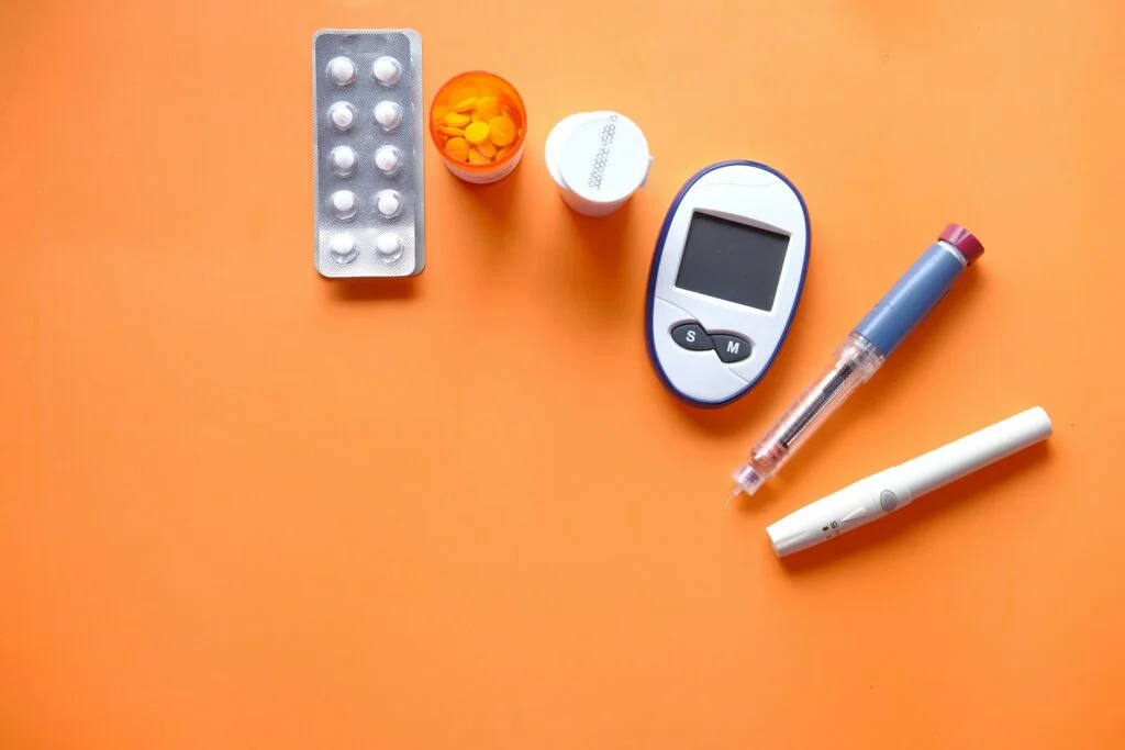 Diabeteksen hoitovälineitä, kuten insuliinikynä ja verensokerimittari.
