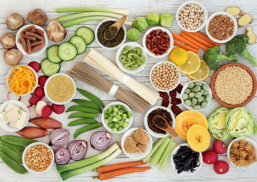 Vihanneksia, hedelmiä ja viljoja aseteltuna pöydälle.