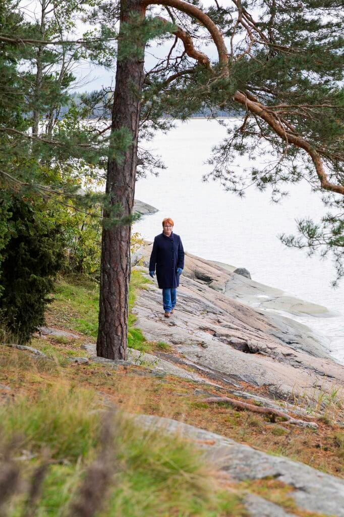 Anne Mattila kävelee merenrantakallioilla.